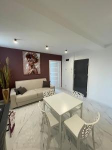 a living room with a couch and a table and chairs at Nela in Carini