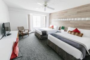 a hotel room with two beds and a television at Elk + Avenue Hotel in Banff