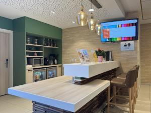a kitchen with a counter and a bar with a chair at DOMITYS - Elixir in Dreux