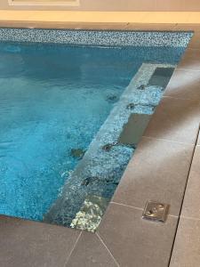 a swimming pool with blue water and rocks at DOMITYS - Elixir in Dreux