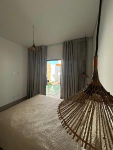 a bedroom with a bed with a large window at Casa Green Ville in Prado +2 photos