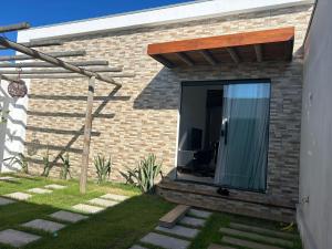 a brick house with a large glass window on it at Casa Green Ville in Prado