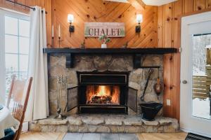 a fireplace in a living room with wooden walls at Charme-Nord in Sainte-Agathe-des-Monts