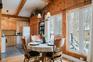 a kitchen and dining room with a table and chairs at Charme-Nord in Sainte-Agathe-des-Monts