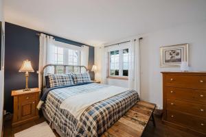a bedroom with a bed and a dresser and a window at Charme-Nord in Sainte-Agathe-des-Monts