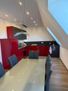 a kitchen with a table and chairs and red cabinets at Hof Volkmann in Nordkirchen