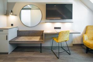 a desk with a mirror and a chair at Hotel Sonne Rudersberg in Rudersberg