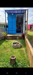 a blue shack in a yard next to a fence at POUSADAGiraGarden Containers in Arroio do Silva