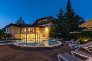 a large house with a swimming pool in front of it at Hotel Marko in Sankt Kanzian