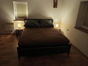 a bed in a room with two lamps on two tables at Stare Sioło in Wysokie