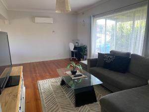 a living room with a couch and a table at Private 3Bed Home with Large Deck Central Location in Eaglehawk