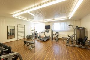 a gym with several treadmills and machines in a room at Hotel Marko in Sankt Kanzian