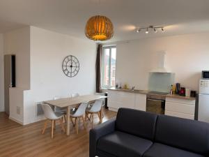 a living room with a table and chairs and a kitchen at ABEILLE - 2 chambres et 1 canapé-lit, 1er étage, parking in Castelsarrasin