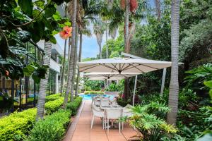a patio with a table and chairs under an umbrella at Garden Court Hatfield in Pretoria
