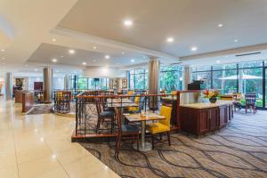 a restaurant with tables and chairs and windows at Garden Court Hatfield in Pretoria