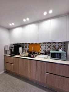 a kitchen with wooden cabinets and a microwave at Bom Stay in Seoul