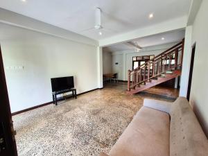 an empty living room with a couch and a television at Lake view Oasis Koggala in Malalagamaduwa