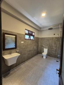 a bathroom with a sink and a toilet at Lake view Oasis Koggala in Malalagamaduwa