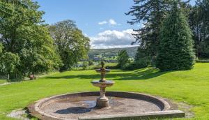 a fountain in the middle of a grassy field at Waterfoot Park in Pooley Bridge