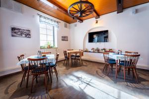 a dining room with tables and chairs and a flat screen tv at Formanka Hanušovice in Hanušovice