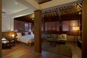 a bedroom with a bed and a couch in a room at Juan Villa Legian in Seminyak +111 photos