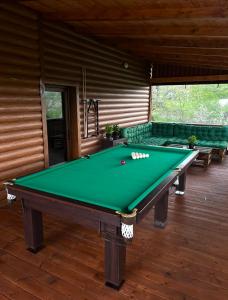 a green pool table in a room with a couch at MiS Family house з чаном та сауною in Kosiv