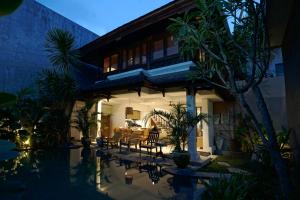 a villa with a swimming pool at night at Juan Villa Legian in Seminyak