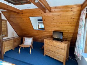 a room with a tv and a wooden wall at Ferienhaus Winkelwerk in Goslar