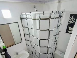 a bathroom with a shower curtain and a sink at departamento completo, Luminoso, cómodo y bien ubicado ideal eventos river movistar arena tecnopolis in Munro