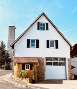 a white house with a white garage at Ferienwohnungen Etzl in Bad Mergentheim