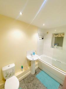 a bathroom with a toilet and a sink and a tub at Stay with LL in Doncaster