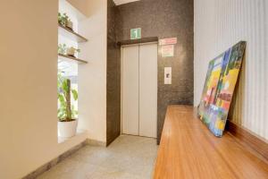 a hallway with a door and a painting on a table at Collection O Delta Electronics Metro Station Bangalore Formerly New Kick in Kammasandra