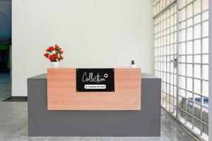 a sign on a counter with a flower on it at Collection O Delta Electronics Metro Station Bangalore Formerly New Kick in Kammasandra