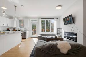 a kitchen and living room with a couch and a table at Quiet and Convenient Retreat in Hammonds Plains