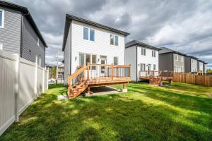 a backyard with a wooden deck and houses at Quiet and Convenient Retreat in Hammonds Plains