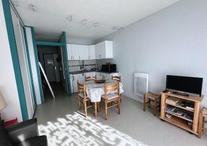 a living room with a table and a kitchen at Studio Anouk 4 personnes à Laruns in Laruns