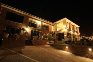 a brick house with lights on it at night at Bay View Guest House in Somerset West