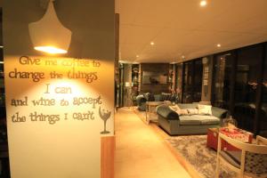 a living room with a sign that says give me coffee to change the things i at Bay View Guest House in Somerset West