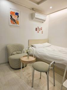 a bedroom with a bed and a table and chairs at Bom Stay in Seoul