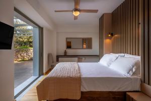 a bedroom with a large bed with a ceiling fan at Dio Escapes Villas in Poulithra +83 photos