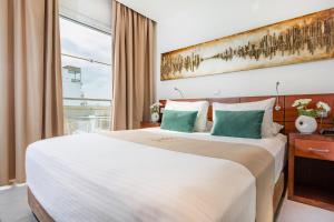 a hotel room with a large bed and a window at Achilleos City Hotel in Larnaca +46 photos