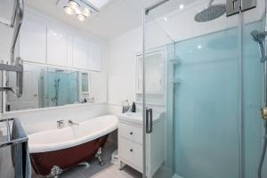 a bathroom with a tub and a glass shower at Spacious Multifunctional 5BR Retreat with Backyard in Bayswater +24 photos
