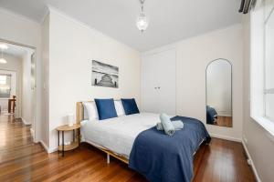 a bedroom with a large bed with blue pillows at Spacious Multifunctional 5BR Retreat with Backyard in Bayswater