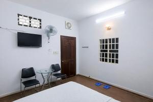 a room with a table and two chairs and a tv at Nhà Nghỉ Long Nhi in Nhơn Trạch +9 photos