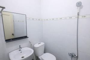 a white bathroom with a toilet and a sink at Nhà Nghỉ Long Nhi in Nhơn Trạch