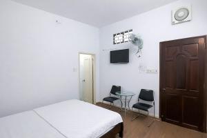 a bedroom with a bed and two chairs and a table at Nhà Nghỉ Long Nhi in Nhơn Trạch