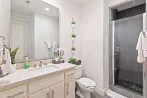 a bathroom with a toilet and a sink and a shower at King-Sized Comfort with Rooftop Skyline Views in Dallas +44 photos