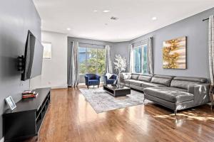 a living room with a couch and a television at King-Sized Comfort with Rooftop Skyline Views in Dallas