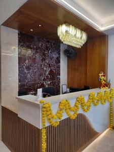 a lobby with a reception counter with yellow decorations at Hotel Roop Cliff, Bhopal in Bhopal