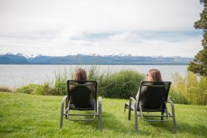 two people sitting in chairs looking at the water at Alma Del Lago Suites & Spa in San Carlos de Bariloche +42 photos